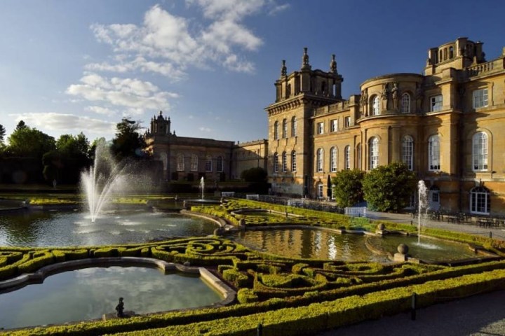 a castle with water in the background with Blenheim Palace in the background
